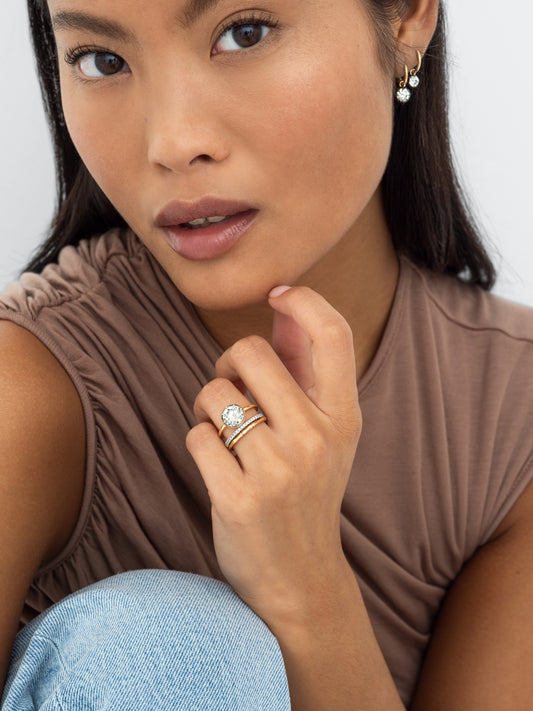 Close-up of a woman wearing a 2.19ct diamond ring in white gold with a button back design, paired with delicate gold hoops, showcasing timeless craftsmanship and contemporary elegance. View 3