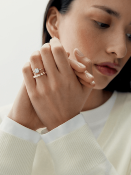 Close-up of a woman's hands gently clasped, featuring a contemporary white gold ring with a 0.90ct diamond, showcasing refined craftsmanship and elegant design.
