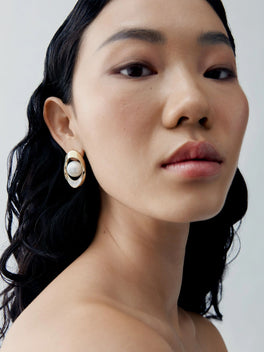 Close-up portrait of a pearl and carre cut diamond earring in blackened gold, showcasing Jessica McCormack's antique-inspired contemporary style