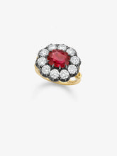 Yellow gold ring featuring a deep red ruby center stone surrounded by a halo of round brilliant diamonds in blackened white gold settings, showcasing antique-inspired craftsmanship.