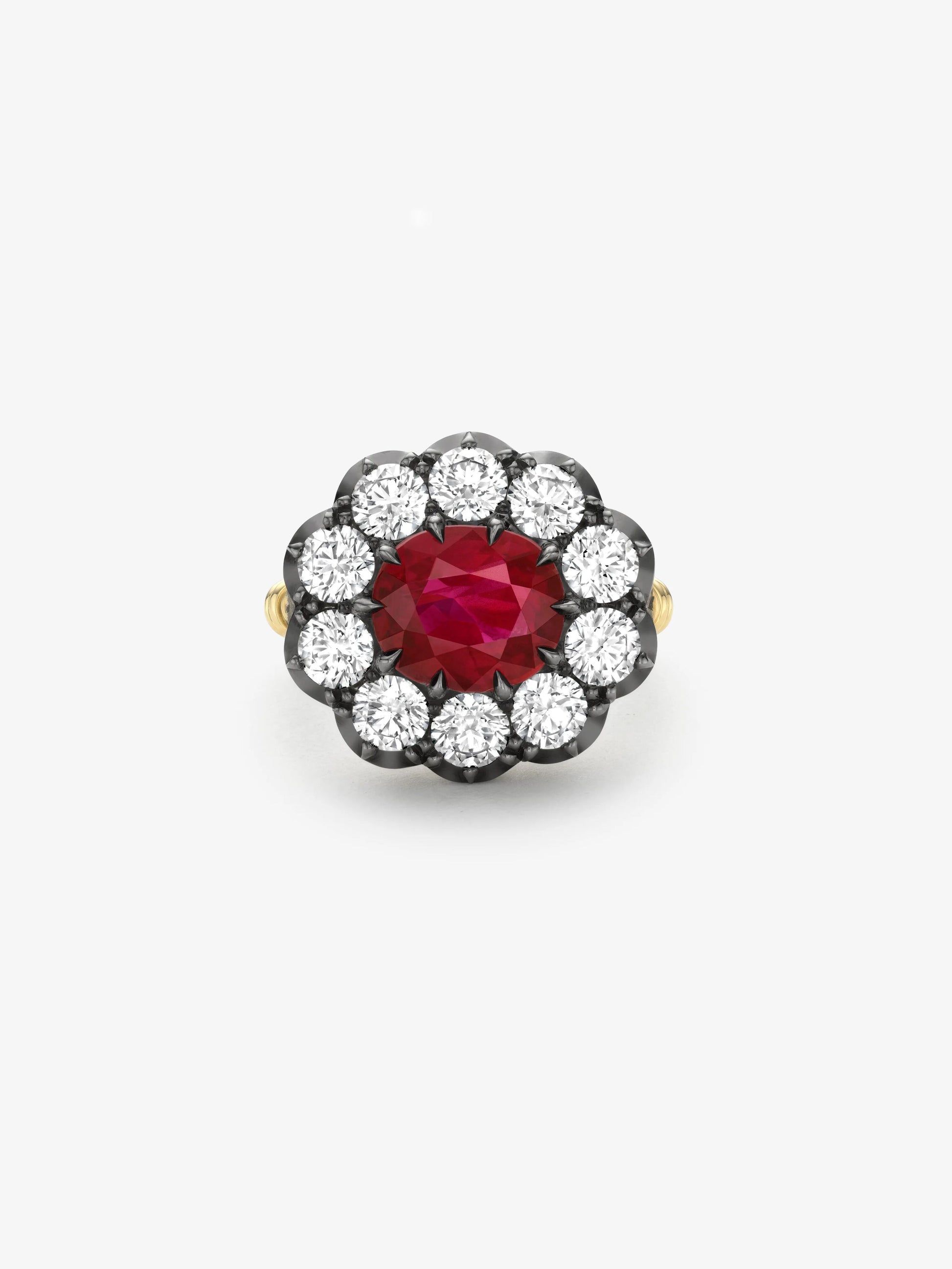 Ring featuring a vibrant ruby center stone surrounded by a halo of round diamonds in an antique-inspired blackened gold setting with yellow gold band accents. View 1