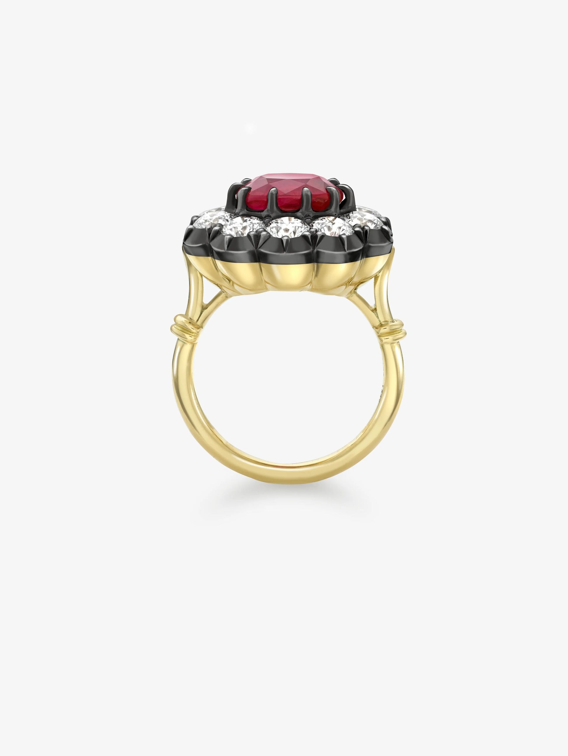 Yellow gold ring featuring a vibrant ruby center stone surrounded by a halo of diamonds set in blackened white gold, combining antique inspiration with contemporary design. View 3
