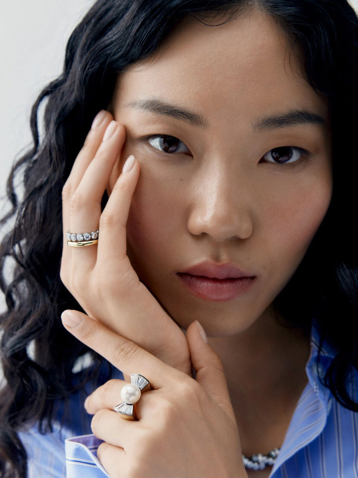 Portrait of a model wearing a pearl and diamond ring with an antique inspired setting alongside a diamond band by Jessica McCormack View 3