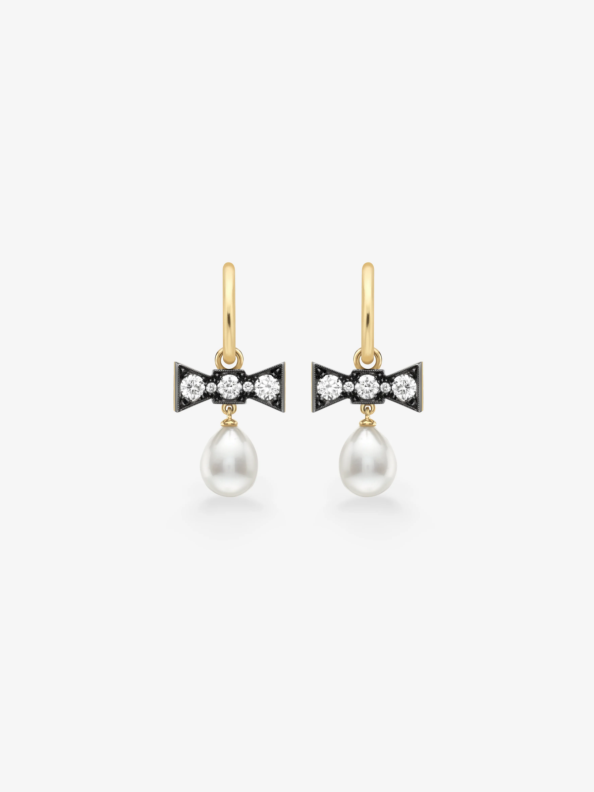 Jessica McCormack bow drop earrings in gold, featuring diamond set blackened bows and luminous white pearl drops. View 1