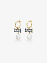 Gold hoop earrings with blackened bow details set with round brilliant cut diamonds and dangling white pearls in a contemporary gypset design