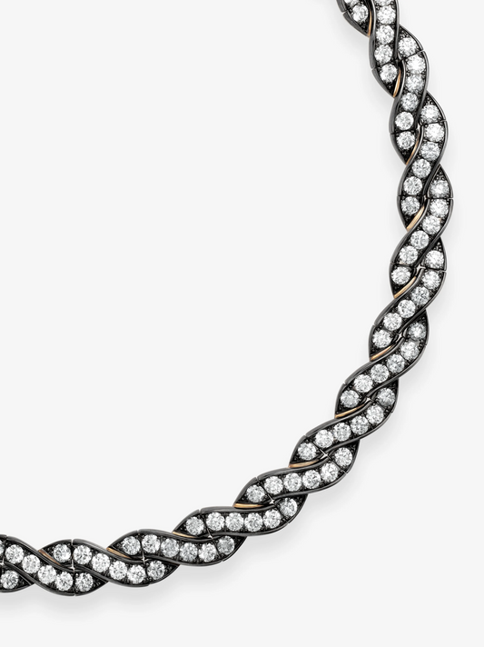 Close-up of a Jessica McCormack diamond and blackened gold necklace with intertwined ribbon links and rows of round diamonds in a sculptural design View 2