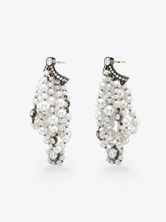 Pair of pearl and diamond drop earrings with clustered white pearls, round diamonds and blackened gold bow details against a white background View 2