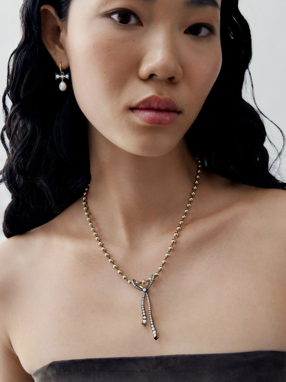 Jessica McCormack diamond ribbon pendant necklace worn on a model, featuring a delicate beaded chain and two slender drop ends. View 3