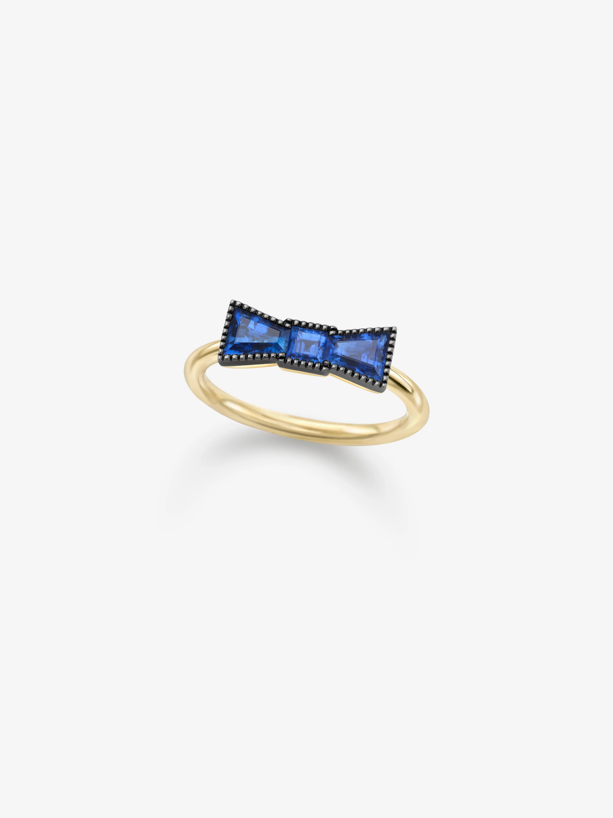 Yellow gold ring featuring a sculptural bow motif set with vivid blue sapphires and contrasting dark detailing on a white background View 2