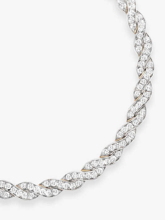 Close-up of a diamond and white gold ribbon necklace with intertwined leaf-like links, showcasing detailed craftsmanship and a sculptural contemporary design View 2