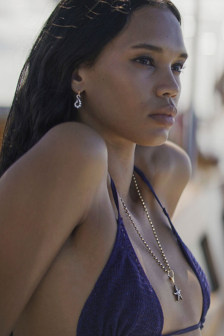Model wears the Off The Hook Earrings & Starfish Pendant