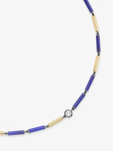 Close-up of a contemporary necklace featuring alternating blue lapis bars and polished gold tubes with a single round diamond set in a signature vintage-inspired setting.
