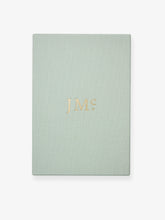 Light green textured jewelry box with gold embossed JM logo, reflecting elegant packaging for a contemporary diamond necklace.