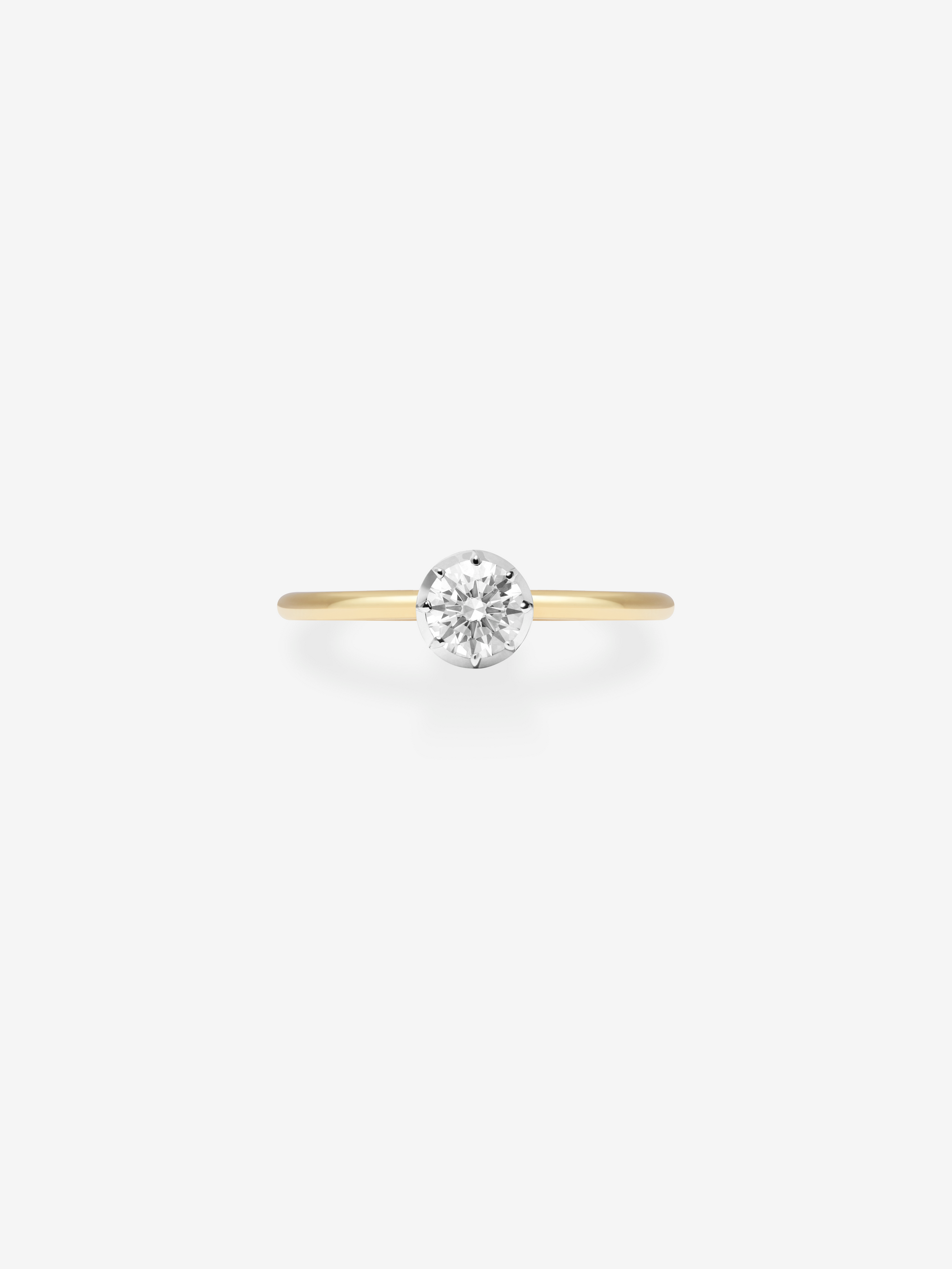 Delicate 0.50ct diamond set in a sleek white gold bezel with a slender yellow gold band, showcasing timeless craftsmanship and modern elegance. View 1
